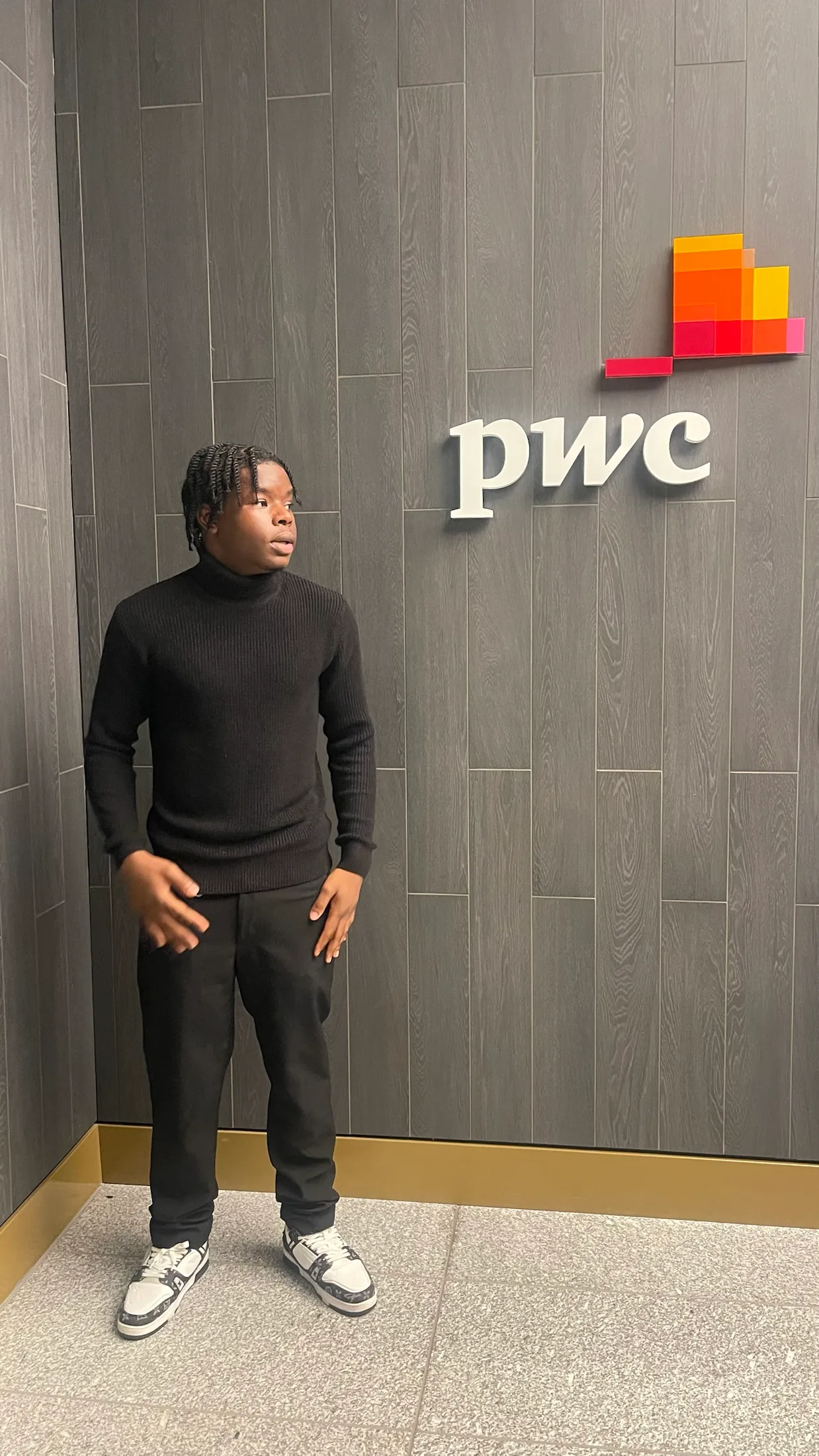 Kevin Awodarow standing beside the PwC logo during the 2024 Spring Insight Programme